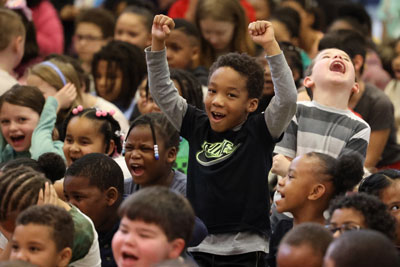 Excited students cheering during school assembly