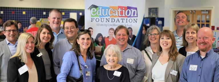 Group of donors standing in front of Education Foundation display