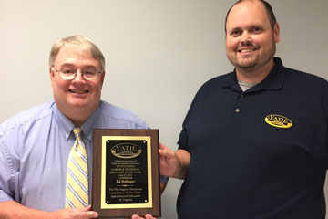 Ed Dellinger holding award with VATIE representative