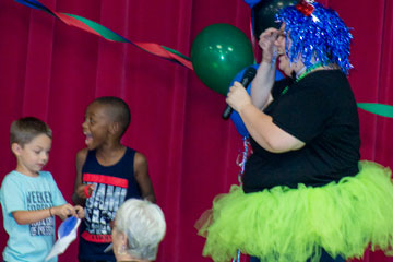 Teacher dressed up in bright colored costume with two students