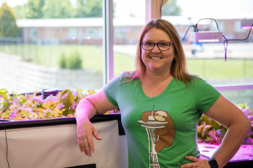 Cathy Drumheller in front of aquaponics system