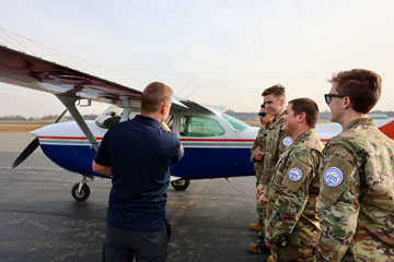 JROTC students and CAP instructor standing in front of plane