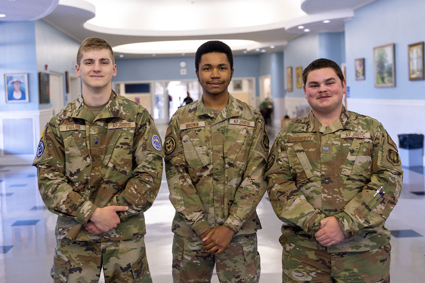 Three JROTC students standing in school lobby