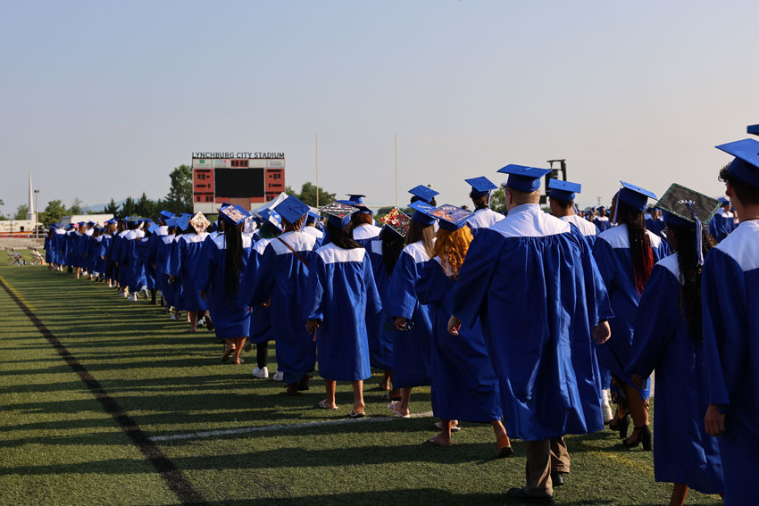 Students in caps and gown walking into graduation ceremony