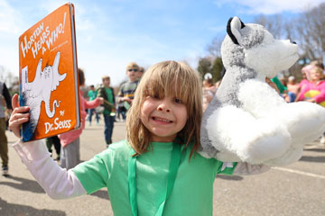 Student holding book and stuff animal