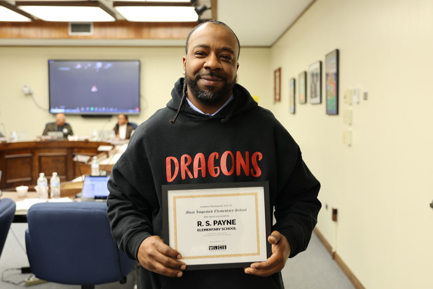 Custodian holding award in School Board Room