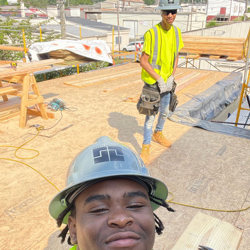 Two students in hardhats on construction site