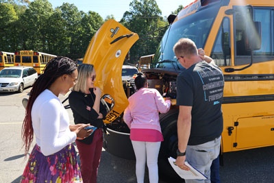 Transportation staff examining new EV bus