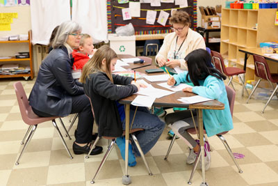 Students at tables brainstorming ideas on paper