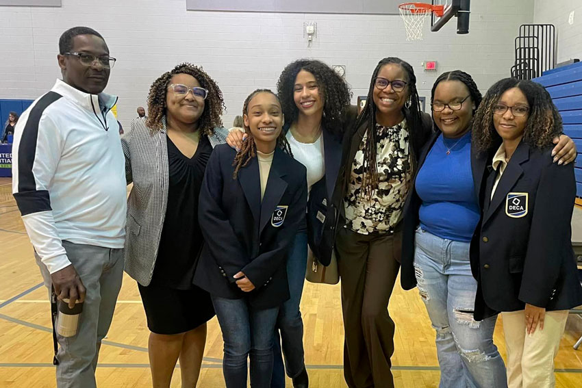 Students with teacher and superintendent in school gym during career fair