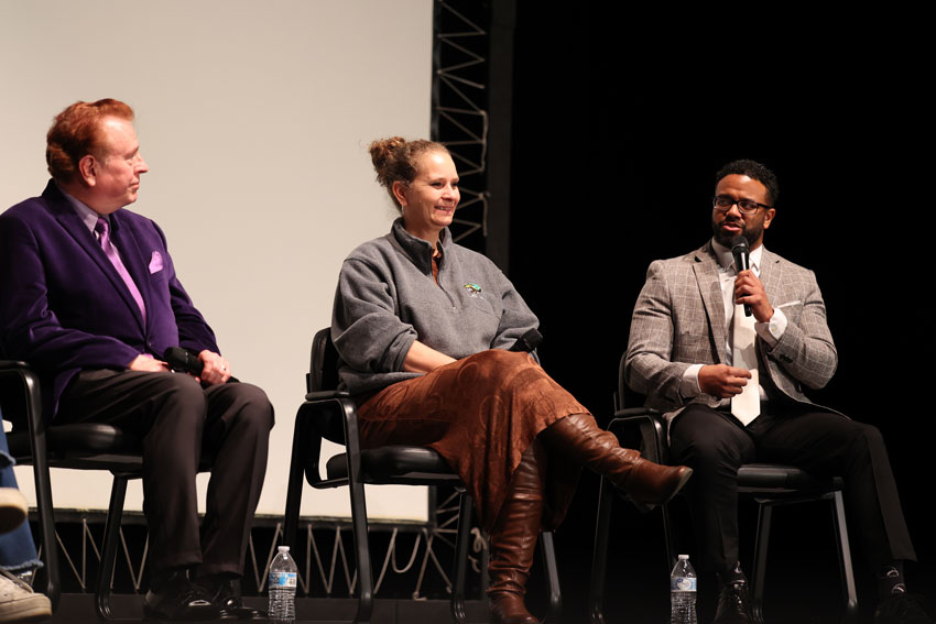 Three panelists on stage speaking