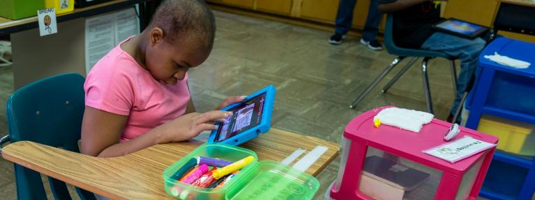 Student at desk using tablet